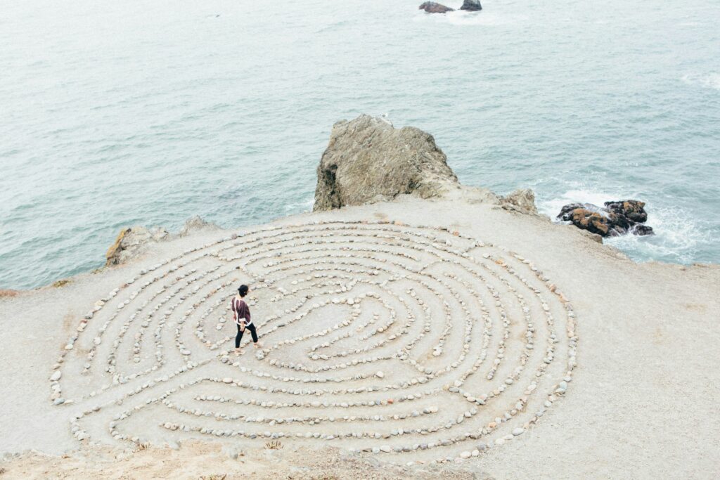 Embodiment Practices as Healing Exercises depicted by a maze or rocks on a beach